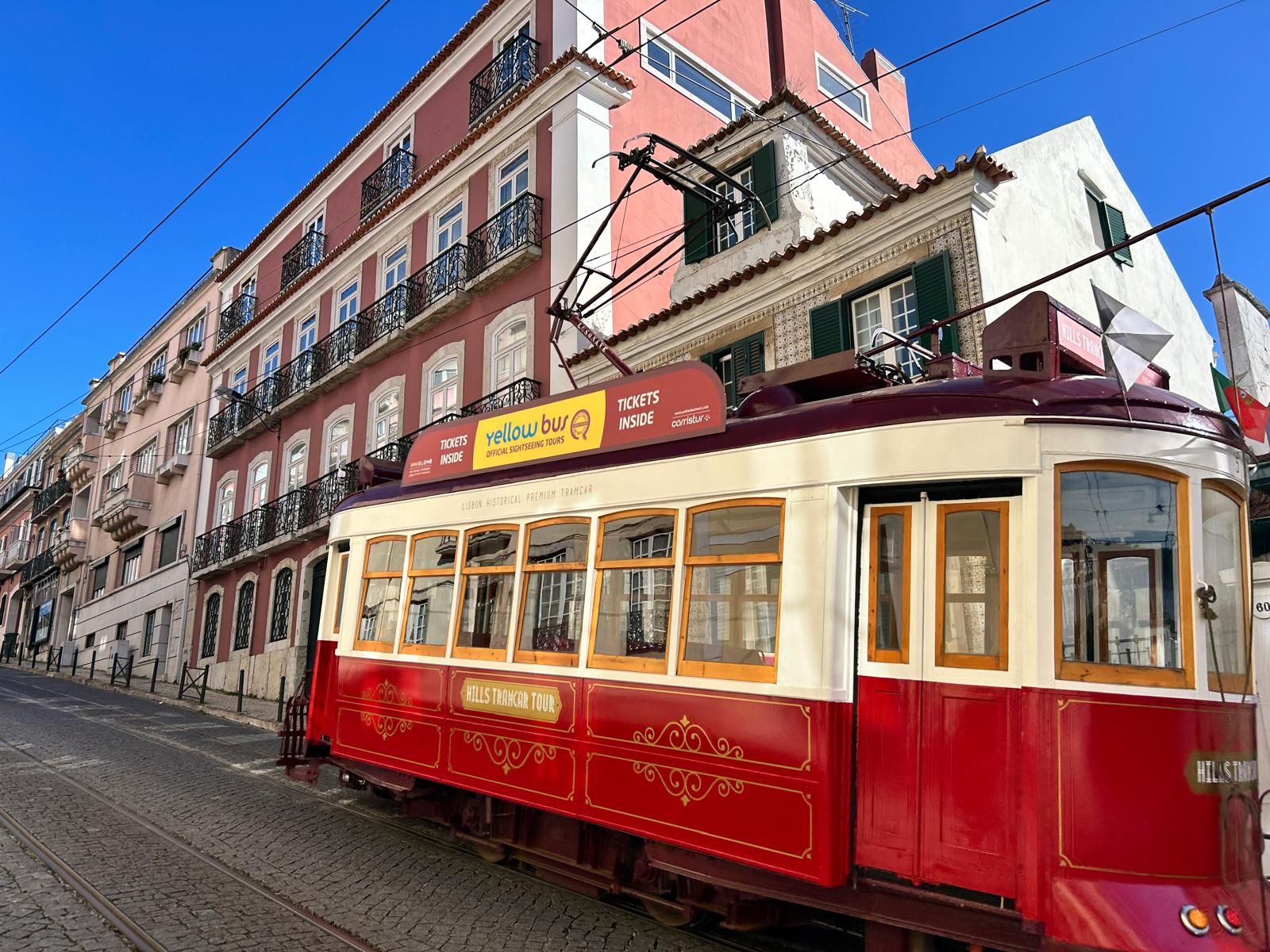 Tramway rouge dans une rue ensoleillée de Lisbonne
